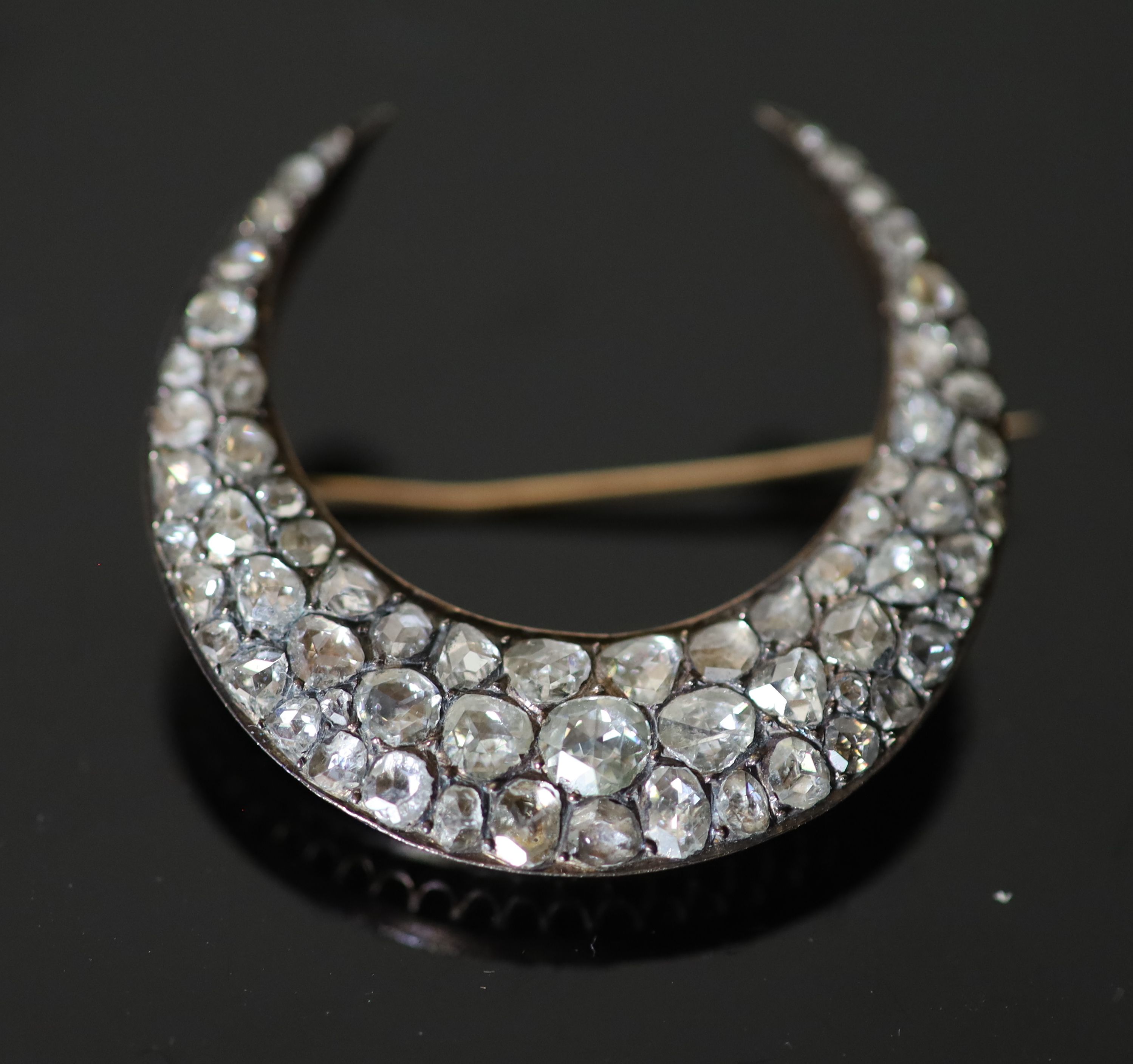 A 19th century French gold and foil backed graduated rose cut diamond set crescent brooch,